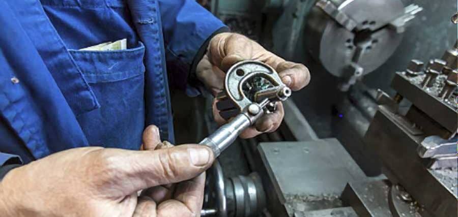 Man-setting-up-his-lathe-cutting-tools