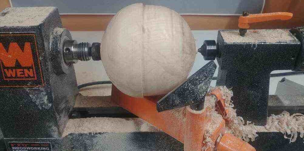 "A round unfinished bowl turning on a wen mini wood lathe"