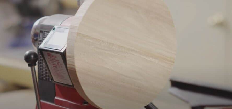 "a piece of round wood bowl blank is attached with the headstock of a lathe"