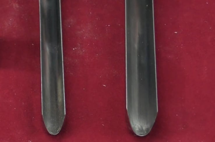 "The edge of two spindle gouges on a red mat"