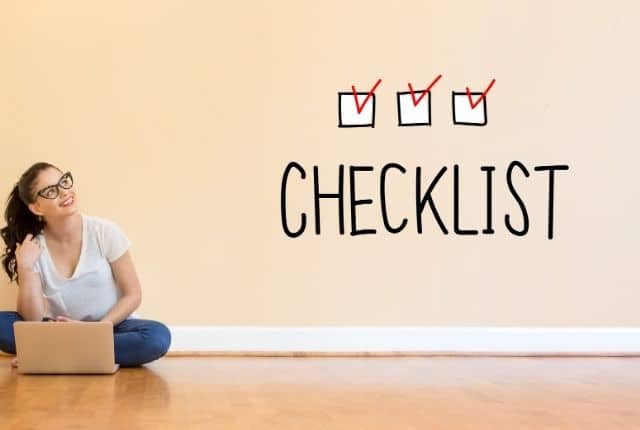 "girl sitting on a floor with a laptop looking at a word in the wall saying checklist""